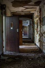 Fototapeta na wymiar Derelict Hallway with Open Doors - Abandoned Rockland State Hospital - New York