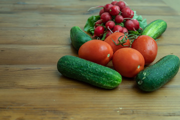 radishes tomato and cucumbers on wooden backround