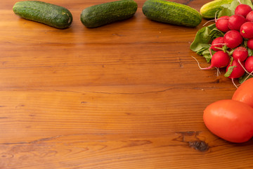 radishes tomato and cucumbers on wooden backround