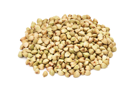 Pile or heap of green buckwheat seeds seen obliquely from above and isolated on white background