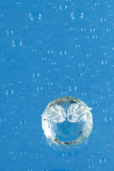 crystal apple on blue water drops background