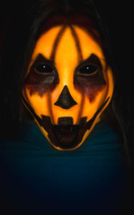 Scary pumpkin face of a halloween creature with opened mouth on dark background