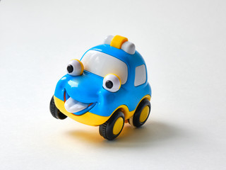 Funny toy car with a smiling face on a white background