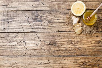 Lemon honey and ginger root on wooden background with copy space. Ingredients for a tonic vitamin...