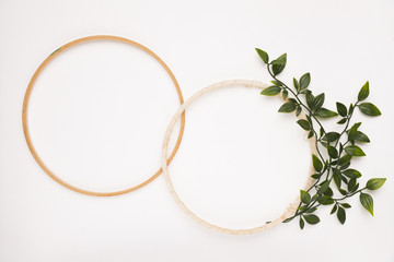 An empty wooden circular frame with leaves on white backdrop