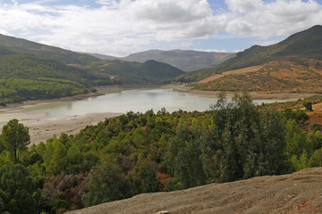 Beautiful scenery on an embankment dam with very few water in front of the green Rif mountains in the North of Morocco, Africa