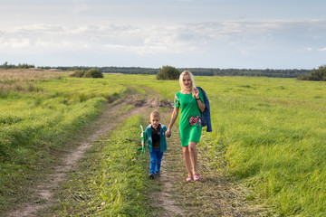 mom and son walk on a rural road