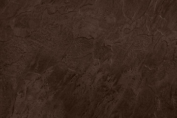 Close up of abstract dark brown stone texture with high resolution.