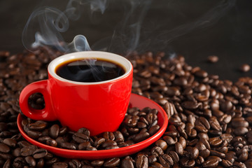 Smoke and red coffee cups on the old table on a black background
