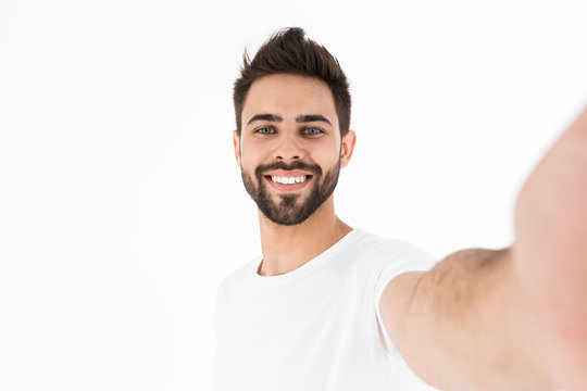 Smiling young brunette bearded man wearing casual outfit