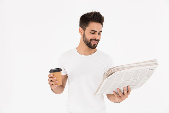 Image of handsome satisfied man drinking coffee takeaway and reading newspaper