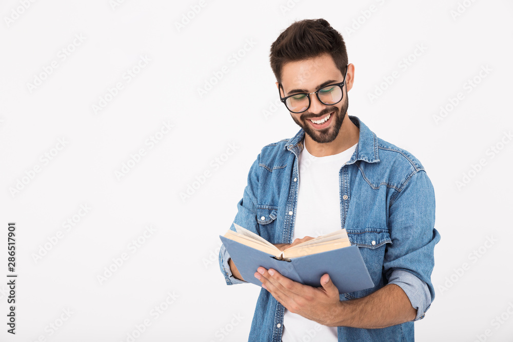 Sticker Image of young happy man wearing eyeglasses reading book and laughing