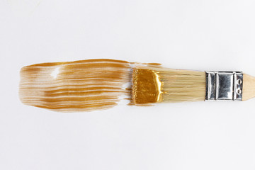 Shiny golden paint and brush
