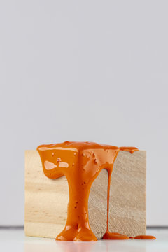 Wooden Cube With Dripping Orange Paint