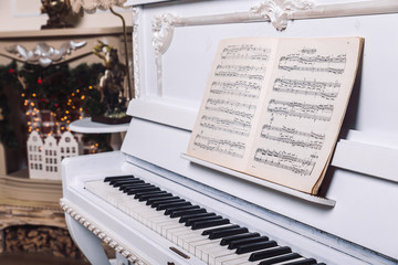 white piano with book with notes on it