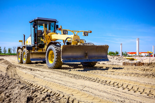 Grader is leveling ground at construction site