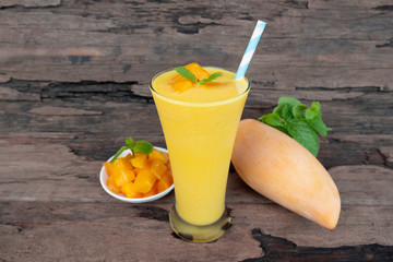 Mango smoothies yellow colorful fruit juice milkshake blend beverage healthy high protein the taste yummy In glass,drink to lose weight drink episode morning on a wooden background.