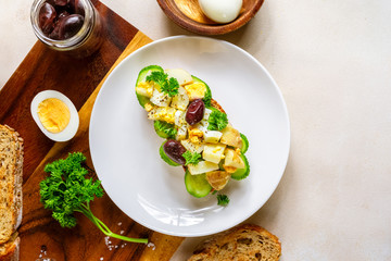 Open sandwich with traditional German potato salad, bread, eggs, olives, top view