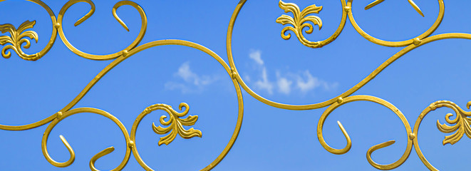 Painted gold paint forged metal products against the sky as a background for design
