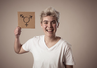 Portrait of happy proud and confident trans teenager man holding transgender symbol - obrazy, fototapety, plakaty