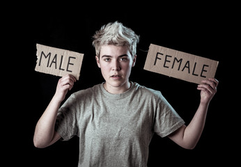 Transgender teenager breaking the word FEMALE into MALE. Gender identity and human rights concept.