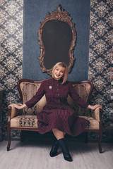 work concept, model business - fashionable stylish portrait of a woman with white short hair. model in purple dress with brooch sitting on chair