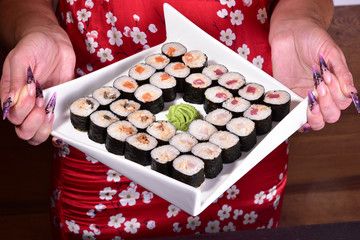 Sushi set compositionally located on a dark surface.