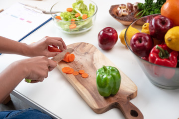 In selective focus of carrot was cutting by knife, preparing for salad meal by beauty woman,healthy food,good for life,blurry light around