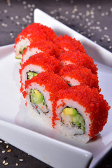 Sushi set compositionally located on a dark surface.