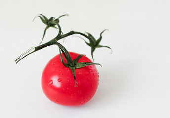 Red tomate with drops of water isolated on a light gray background
