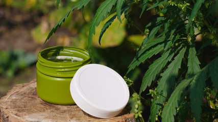 Side view of a jar of CBD or hemp salve. Macro close up of jar with cream of biological and...