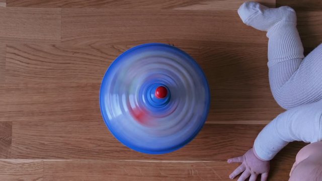 Baby Crawling on Parquet Floor and Spinning Top Spinning