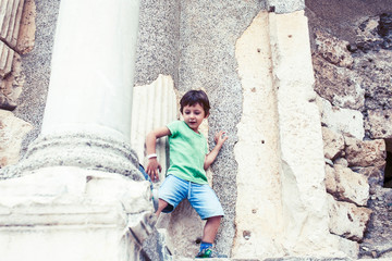 Obraz na płótnie Canvas little boy exploring ancient architecture, lifestyle people on summer vacation close up