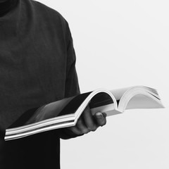 man in black t-shirt reading book on white background