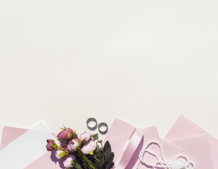 Pink envelopes next to bouquet of roses with copy space