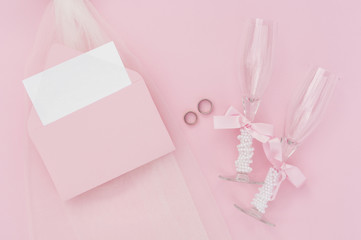 Champagne glasses next to wedding invitation