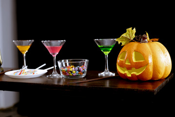 Ghost pumpkins, candies, and drinks on the table at the Halloween party.