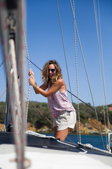Beautiful young woman traveling along Mediterranean sea on sail boat