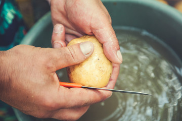 man hand potatoes and knife
