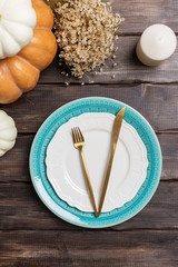Empty plate with harvest decor and golden tableware