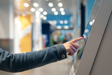 Woman is touching a touch screen of interactive panel close up. - obrazy, fototapety, plakaty