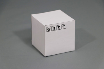 White carton box with fragile symbol beside it, paper packaging for put products.
