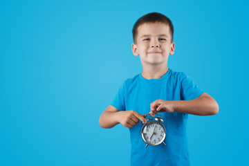 kid boy holding clock alarm