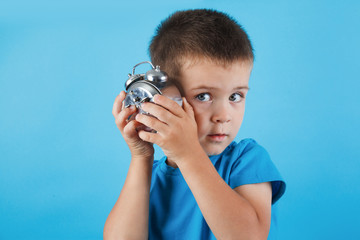 Fototapeta premium kid boy holding clock alarm