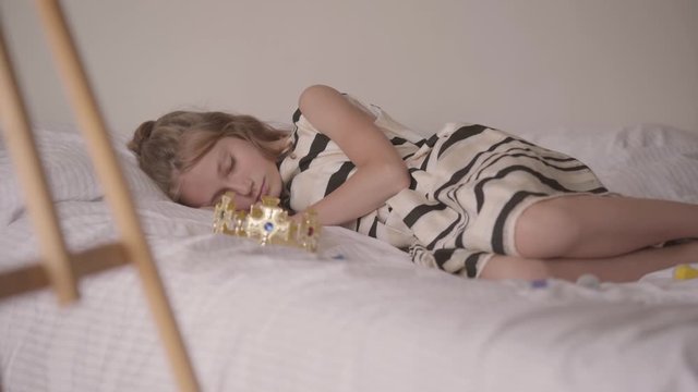Cute sleeping calm caucasian girl lying in his comfortable bed. The child resting after playing games. Carefree childhood, resting at home