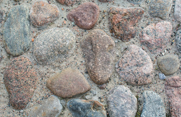 Background of cobblestones. Multi-colored pavement. Road texture
