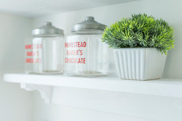 Transparent jars for food on white shelf in the kitchen.