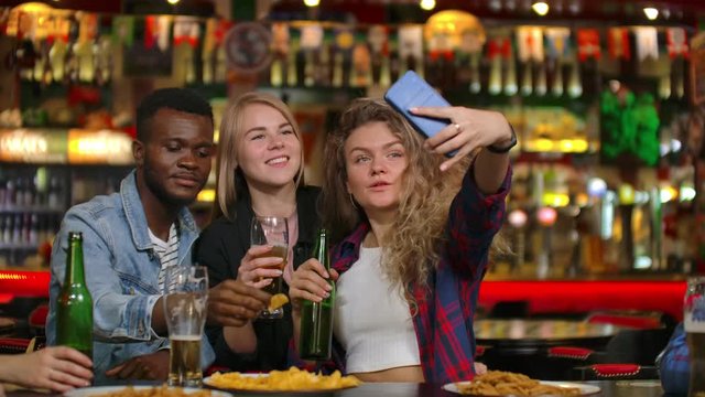 In the Bar or Restaurant Hispanic man Takes Selfie of Herself and Her Best Friends. Group Beautiful Young People in Stylish Establishment