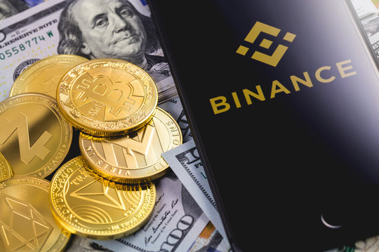 Apple iPhone and Binance logo, with dollars and cryptocurrency. Binance is a cryptocurrency exchange. Ekaterinburg, Russia - September 19, 2018