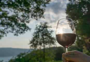 Ein glas roter wein mit Sonnenuntergang als Sundowner im Sommer